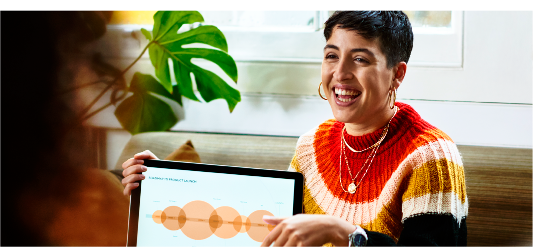 Happy woman giving a presentation with a laptop.