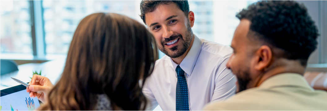 Young male adviser with beard, white shirt and blue tie, charts with couple regarding their investment options