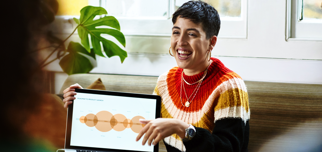 Happy woman giving a presentation with a laptop.