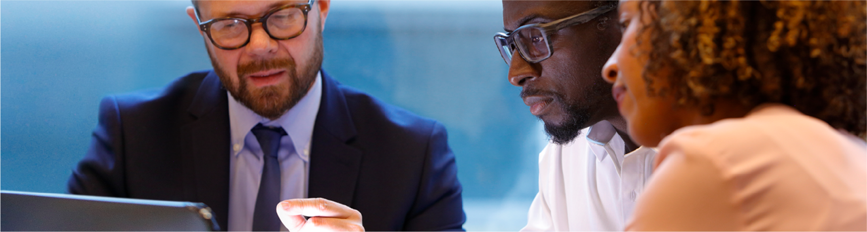 Male adviser chatting through data on a laptop to a male client with white shirt and a female client with a beige jacket