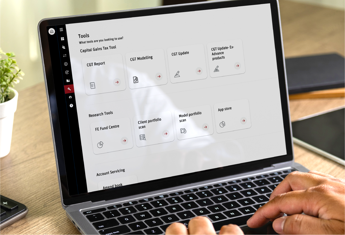 Person using a laptop displaying the Scottish Widows Platform secure website with various tools listed