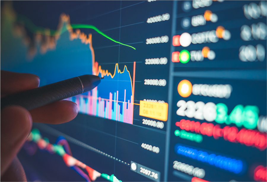 Abstract close up of an investment screen showing colourful chart data with a hand holding a stylus onto the screen