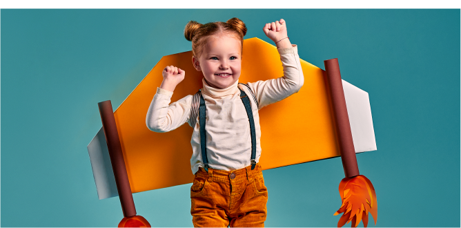 Small happy child with cardboard rocket attached to her back.