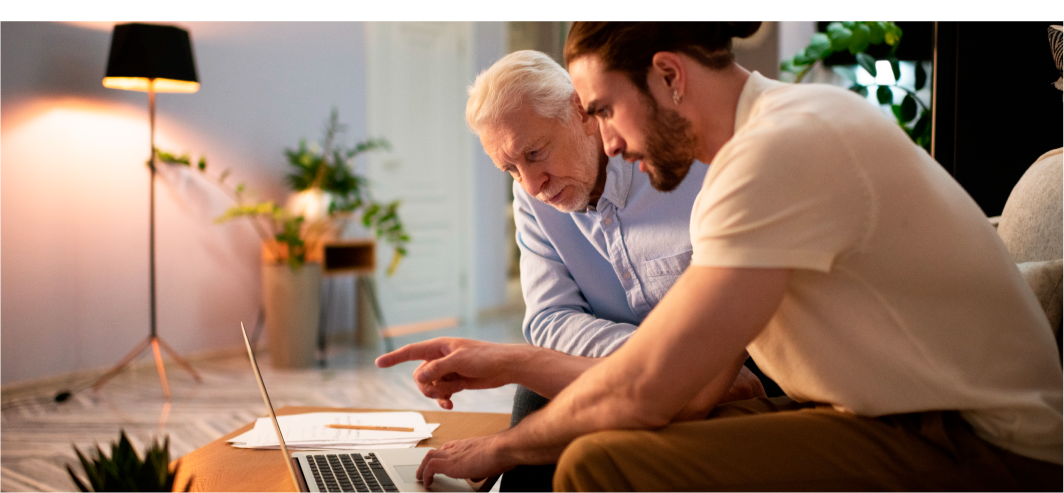 Two professional men sitting on sofa discussing business on a laptop